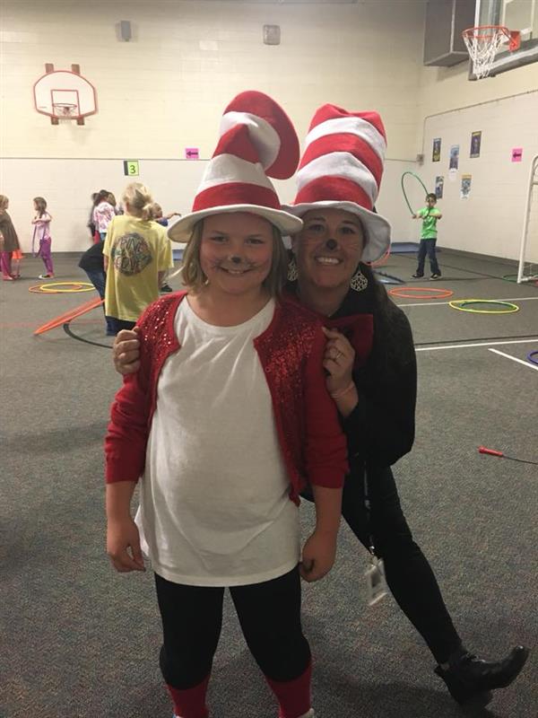 Student and teacher wearing tall red- and white-striped hats, as a nod to Dr. Seuss' Cat in the Hat